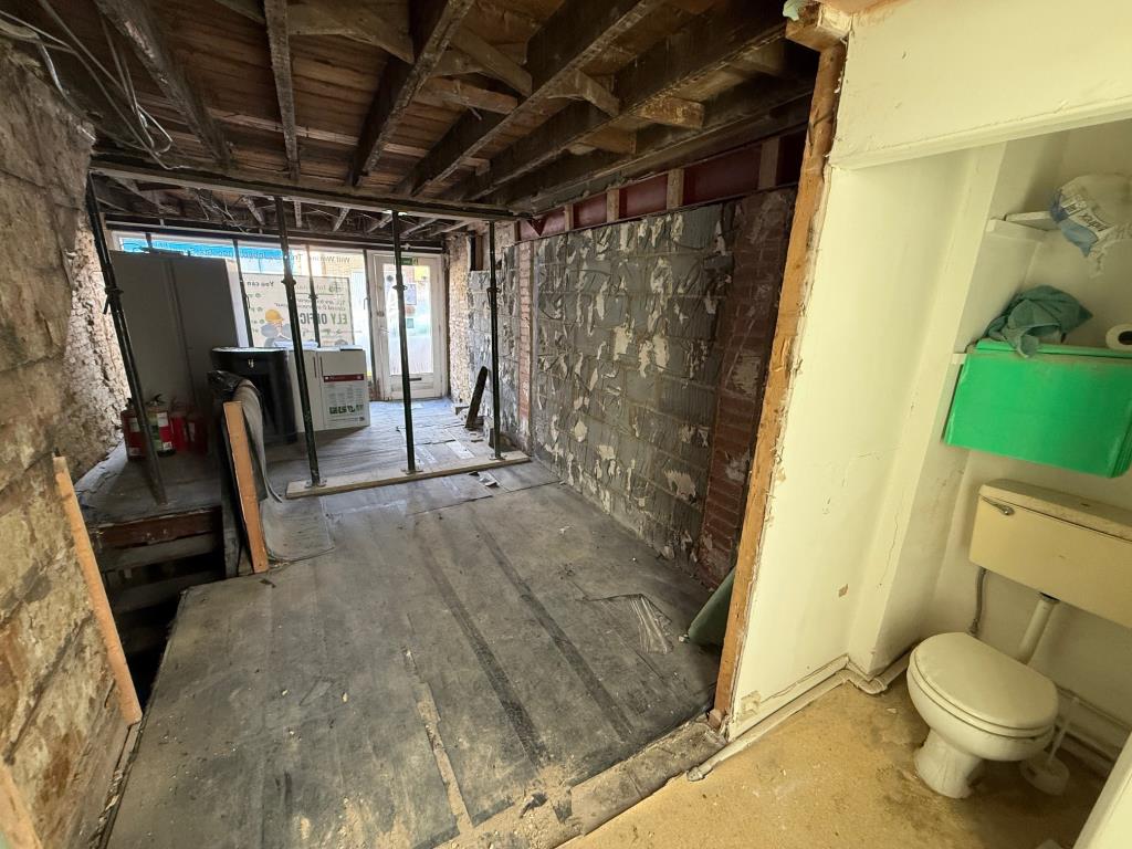 Lot: 88 - MIXED USE BUILDING FOR IMPROVEMENT AND REPAIR - Shop area with toilet and stairs down to basement